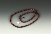 A strand of 108 sandalwood and coral prayer beads