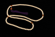 A STRAND OF PRAYERS BEADS CONSISTING OF 108 IVORY AND AMBER BEADS
