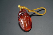 A WELL CARVED AMBER PENDANT
