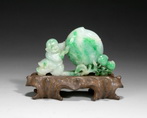 A JADEITE CARVING OF A CHILD AND A PEACH BRANCH, WITH AN ORIGINAL CARVED HORN STAND