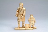 A Japanese bone carved man and child figure