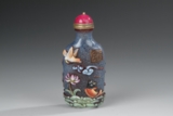 A BLUE GLASS SNUFF BOTTLE WITH EMBELLISHMENTS