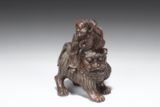 A CARVED BAMBOO FIGURE OF IMMORTAL ON A LION