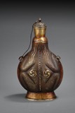 AN UNUSUAL CARVED BRONZE BOTTLE