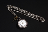 A SILVER POCKET WATCH WITH CHAINS