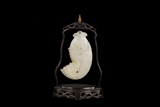 A WHITE JADE CARVING OF FISH WITH WOODEN STAND