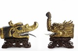 A SET OF TWO GILT BRONZE DRAGON HEADS WITH STAND