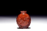 AN AMBER CARVED 'CHILONG' SNUFF BOTTLE