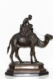A BRONZE STATUE OF FIGURE UPON CAMEL