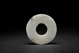 AN ARCHAISTIC WHITE JADE CARVED DISC
