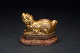 A GILT BRONZE MODEL OF MYTHICAL BEAST WITH STAND