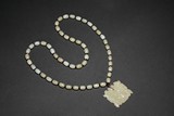 A WHITE JADE 'MYTHICAL BEAST' AND BEAD NECKLACE