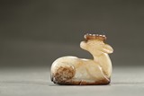 A WHITE AND RUSSET JADE CARVING OF DEER