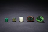 A GROUP OF FIVE JADEITE RINGS AND BUCKLES