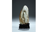 A WHITE JADE CARVED 'GUANYIN AND CHILD' BOULDER WITH SKIN