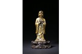A CHINESE GILT BRONZE FIGURE OF STANDING ANANDA
