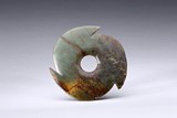 AN ARCHAIC GREEN AND RUSSET JADE NOTCHED DISK