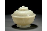 AN IMPERIAL WHITE JADE BUDDHIST 'EIGHT MOTIF' BOWL AND COVER