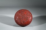 A CINNABAR LACQUER CARVED BOX AND COVER