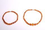 A GROUP OF TWO CARVED AMBER BRACELETS 