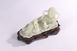 A WHITE JADE CARVING OF RECUMBENT GUANYIN